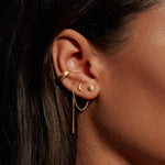 Close-up of a model wearing the Light and Love Gold Ear Cuff along with other gold earrings, showcasing a harmonious blend of spiritual jewelry. The look emphasizes elements like the sun and moon, enhancing the charm's meaningful representation in meditation and self-expression.