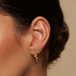Beauty is Timeless Snake Stud Earrings showcased on a model's ear, a perfect embodiment of spirituality and elegance. These talisman earrings symbolize abundance and intuition, making them a meaningful accessory for yoga and meditation practices.