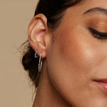 Close-up of a model wearing Embrace Simplicity Silver Hoop Earrings, showcasing their shimmering allure against her skin. These earrings are a beautiful addition to spiritual practices, embodying the essence of protection and manifestation in both yoga and daily adventures.