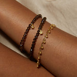 Close-up of the Joyful Bell Bracelet on a wrist among other bracelets, highlighting its charm and significance in spiritual practices, meditation, and as a talisman.