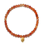 Rooted in Strength Lotus Carnelian Gemstone Bracelet featuring orange carnelian beads and a golden lotus leaf pendant, perfect for spiritual jewelry, meditation, and use in yoga practices for protection and manifestation.