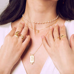 A display of layered jewelry including the Keeper of Positivity Eye Blue Topaz Ring, surrounded by other spiritual jewelry pieces that evoke protection and meaningful energy for meditation enthusiasts.