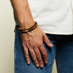 A close-up of a man wearing two Men's Sacred Insight Tiger Eye Gemstone Bracelets stacked on his wrist, showcasing the bracelet's stylish design and spiritual significance, ideal as a meaningful amulet and supportive accessory for meditation and yoga.
