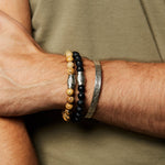 Stylish display of the Men's Blessings and Balance Hamsa Jasper Gemstone Bracelet worn alongside other bracelets, representing spiritual jewelry that embodies protection, meaning, and harmony, ideal for yoga practitioners and those interested in zodiac connections.