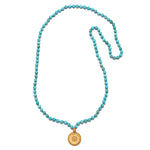 Beyond the Horizon Turquoise Mala featuring 108 turquoise beads, an 18kt gold plated medallion, and white topaz stars, perfect for meditation and spiritual jewelry. This mala serves as a talisman for manifestation and embodies the meanings of vitality and protection found in sun and moon symbolism.