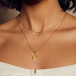 A model showcases the Bloom in Peace Lotus & Tourmaline Necklace, featuring a delicate lotus flower pendant symbolizing new beginnings. This spiritual jewelry enhances your meditation practice and serves as a meaningful talisman for protection and manifestation during yoga sessions.