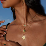 A close-up of the Cradled in Protection Gold Hamsa Necklace on a model, highlighting its intricate design amidst a sunny outdoor backdrop, representing the essence of spiritual jewelry, protection, and the beauty of meaningful talismans.