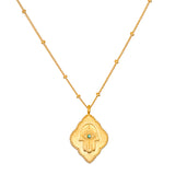 Cradled in Protection Gold Hamsa Necklace, an intricately designed spiritual jewelry piece symbolizing protection and blessings. This talisman features a hamsa hand with an evil eye and emerald gemstone, making it a meaningful charm for meditation and manifestation in your yoga practice. Perfect for those who resonate with zodiac energies, this necklace embodies the essence of sun and moon, enhancing your spiritual journey.