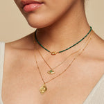 A model showcasing the Cradled in Protection Gold Hamsa Necklace layered with other delicate necklaces, embodying spiritual jewelry themes like meditation and protection, perfect for yoga enthusiasts seeking meaningful charms and manifestation.