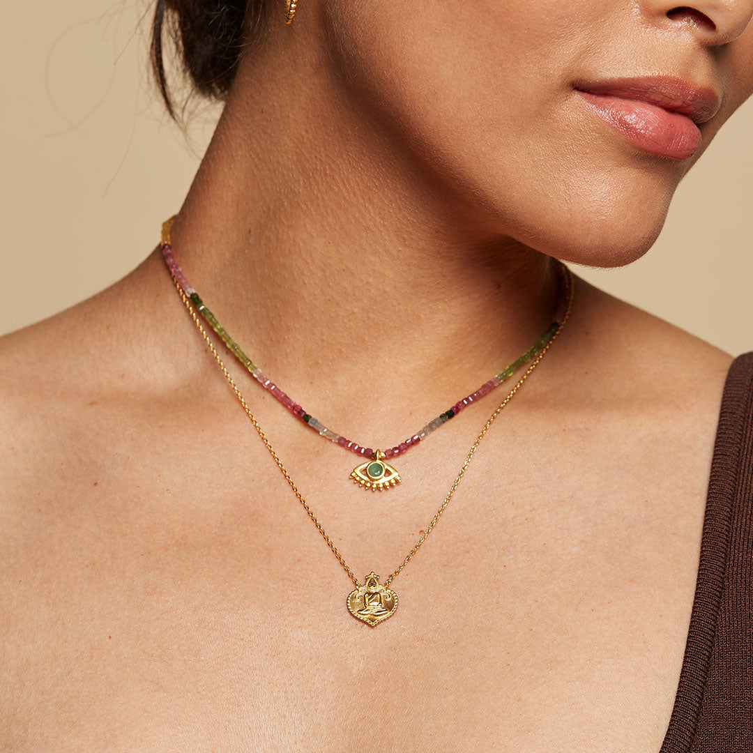 Model wearing the Peaceful Buddha Gold Necklace layered with other spiritual jewelry, highlighting an elegant style. This necklace, ideal for yoga enthusiasts, embodies the meaning of growth and charm in spirituality.