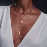 A woman wearing the Illuminated Path Gold Moon Necklace, showcasing its delicate crescent moon pendant and star charm, symbolizing spiritual jewelry and protection. This piece is perfect for meditation and manifestation, enhancing the wearer's yoga practice and connection to the sun and moon.