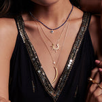 Layered necklaces featuring the Incandescent Glow Gold Starburst Necklace alongside other spiritual jewelry. Ideal for those seeking meaningful talismans for meditation, charm, and personal expression through zodiac-inspired pieces.