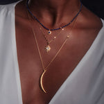 Layered look featuring the North Star Moonstone Starburst Necklace among other spiritual jewelry pieces. Perfect for yoga and meditation enthusiasts, this necklace serves as a meaningful charm for manifestation and connection to the sun and moon.