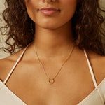 Woman wearing an 18" Chain Charm Necklace, showcasing its elegant charm holder in hammered 18kt gold plate. A beautiful piece of spiritual jewelry that embodies the essence of zodiac signs and meaningful talismans, perfect for meditation and enhancing personal energy.