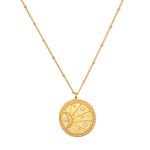 Close-up of the sunburst side of the First Light Gold Medallion Reversible Pendant Necklace, featuring white topaz stars, symbolizing vitality and charm in spiritual jewelry for yoga and protection.