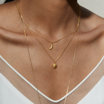 Model wearing the Here Comes the Sun Necklace layered with a crescent moon pendant, showcasing spiritual jewelry designed for meditation and manifestation, perfect for a yoga practice. The pieces convey meaning, representing vitality and protection through the sun and moon.