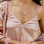 Close-up of a model wearing the Ganesha Hindu God, Path to Success Necklace along with other spiritual jewelry. This beautiful combination signifies spirituality, meditation, and the meaningful essence of talismans in yoga practices, promoting protection and manifestation under the influence of the sun and moon.