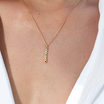 Close-up of the Divine Alignment Gemstone Chakra Necklace worn elegantly, showcasing its vertical pendant adorned with colorful gemstones. This meaningful accessory serves as spiritual jewelry and a meditation gift, embodying mantra and yoga practices. Its symbolic design resonates with the themes of manifestation, protection, and sacred energy, functioning as a powerful amulet for those interested in zodiac connections.