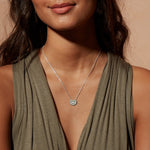 A model wearing the Mini Mandala Silver Necklace, featuring a delicate mandala pendant that embodies spiritual essence and meditation. This meaningful jewelry serves as a protective talisman, ideal for those connecting with their yoga practice and seeking manifestation and charm from the universe.