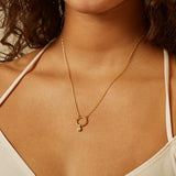 A model wearing the Peridot Bezel Charm on a delicate gold necklace, embodying a connection to zodiac energy and spiritual protection during yoga and meditation practices.