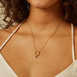 Ruby Bezel Charm worn as part of a stylish necklace, showcasing its significance in spiritual jewelry and talisman practices, ideal for those interested in yoga and manifestation.
