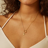 Woman wearing the God Ganesha Charm on a delicate necklace, showcasing spiritual jewelry that represents meaningful connections and guidance. This talisman enhances meditation practices and brings protection, ideal for those who seek balance in their spiritual journey.