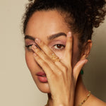 A confident woman partially covering her face while wearing the Beauty is Timeless Snake Adjustable Ring. This ring represents individuality and creativity, embodying elements of spiritual protection and zodiac significance, perfect for yoga and meditation enthusiasts.