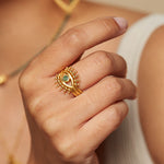 Close-up of a hand wearing the Shed a Light Evil Eye Ring Set, showcasing the golden evil eye design with emerald detail, symbolizing protection and intuition. This spiritual jewelry is perfect for meditation and manifestation.