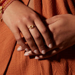 The Reclaim Joy Citrine Sunrise Ring is beautifully worn on a hand, symbolizing manifestation and charm through its radiant design, perfect for spiritual and yoga enthusiasts seeking connection with the sun.