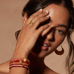 The Reclaim Joy Citrine Sunrise Ring shines on a model's finger, accompanied by bracelets, illustrating its role as a meaningful piece of spiritual jewelry and talisman, representing vitality and warmth.