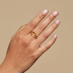 A hand showing the Gold Coils Black Snake Adjustable Ring, symbolizing energy and eternity, perfect for spiritual jewelry and meditation, bringing meaning and manifestation with each wear.