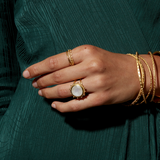 A hand adorned with the Drift Into Daydreams Moonstone Ring, showcasing the intricate beaded starburst design, perfect for those seeking spiritual jewelry, meditation, and meaningful manifestations.