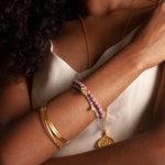 Gold Melody Bracelet Bangle worn on a model's wrist, illustrating its significance as a piece of zodiac-inspired jewelry and a meaningful amulet for modern meditation.