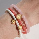 Awaken Love Mandala Rose Quartz Gemstone Bracelet displayed in a stack with other spiritual jewelry, showcasing the delicate golden mandala charm, symbolizing love, compassion, and the connection to the sacred infinite cycle. This meaningful bracelet is perfect for meditation and manifestation practices.