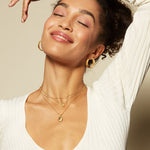 Layered look featuring the Lotus Turquoise Birthstone Locket Necklace - December, which emphasizes its gold and turquoise hues. This stylish spiritual jewelry symbolizes new beginnings and is ideal for those seeking protection and meaning in their accessories.
